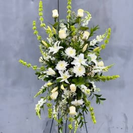 Tall white floral spray on a stand with green accents