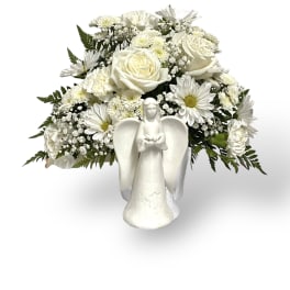White floral arrangement with roses and daisies in an angel vase