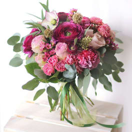 Bouquet of pink and magenta flowers with eucalyptus greenery