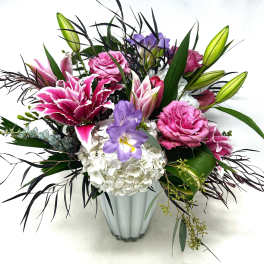 Pink and purple floral arrangement in a clear vase