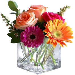 Mixed roses and gerbera daisies in a clear square vase