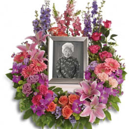 Floral photo tribute wreath with a framed portrait in the center