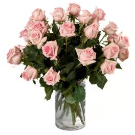 Large bouquet of light pink roses arranged in a clear glass cylinder vase