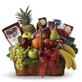 Fruit basket with grapes, apples, bananas, pineapple, and packaged snacks