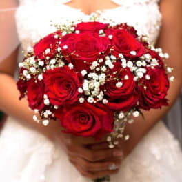 Bride holding a bouquet of red roses with white baby's breath