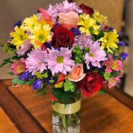Mixed bouquet of roses and daisies in a glass vase