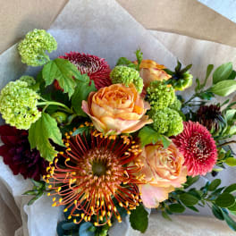 Mixed bouquet with peach roses, red chrysanthemums, and green pom-pom blooms
