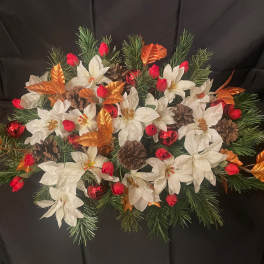Holiday floral centerpiece with white poinsettias, red accents, and pinecones