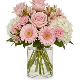 Pink roses and gerbera daisies in a clear glass vase