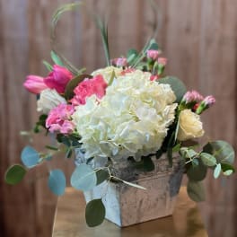 Pink and white floral arrangement in a square vase