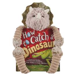 Plush triceratops toy hugging a dinosaur book