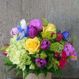Colorful bouquet in a glass vase wrapped with burlap