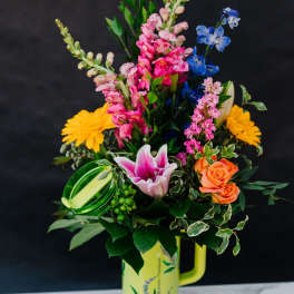 Colorful mixed bouquet in a yellow handled vase