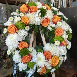 Heart-shaped floral wreath with orange roses and white chrysanthemums