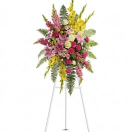 Standing floral spray with pink, yellow, and white flowers on an easel