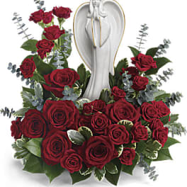Red roses arranged around a white angel statue