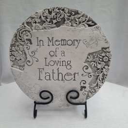 Decorative memorial plaque reading "In Memory of a Loving Father" on a stand