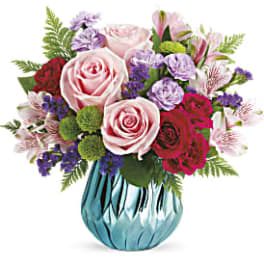 Bouquet of pink and red roses in a blue glass vase