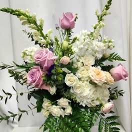 Pink and white roses with white blooms in a vase arrangement