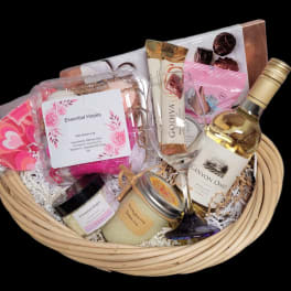 Gift basket with wine, chocolates, bath items, and candles