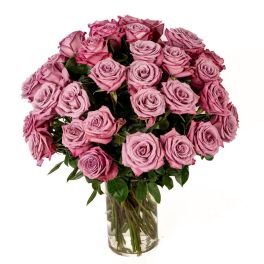 Large bouquet of lavender roses arranged in a clear glass cylinder vase
