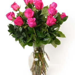 Arrangement of bright pink roses in a clear glass vase with water