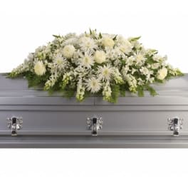 White floral casket spray on a silver casket