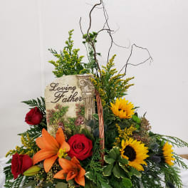 Sympathy floral basket with roses, lilies, and sunflowers around a memorial plaque