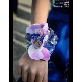 Pink and white orchid wrist corsage with blue ribbon and rhinestone accents