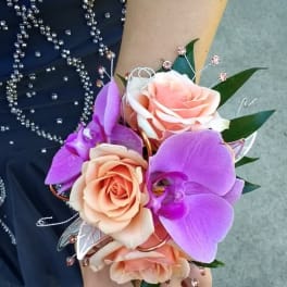 Handheld corsage with peach roses and purple orchids
