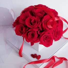 Bouquet of red roses with red ribbon in a white box