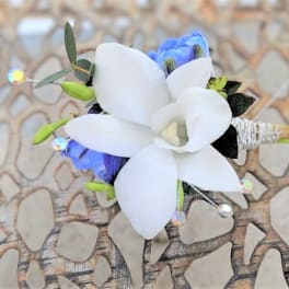 White and blue floral boutonniere with small green buds