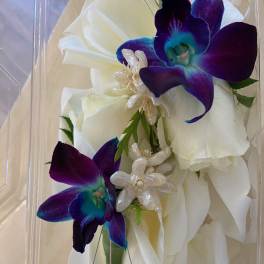 White rose corsage with purple orchids and blue crystal accents
