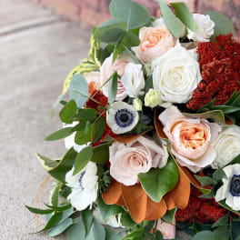 Bouquet of pale roses and white anemones with eucalyptus and rust-colored blooms