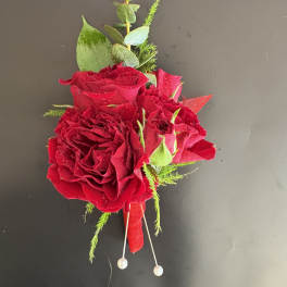 Red rose boutonniere with greenery and pearl pins