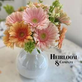Pink and peach gerbera daisies in a clear round vase