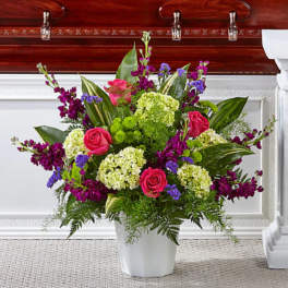 Pink roses and purple flowers in a white vase