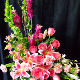 Tall pink floral arrangement with roses, lilies, and carnations