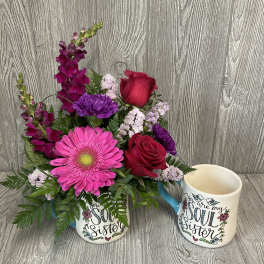 Bouquet in a mug with pink and purple flowers beside a matching sister mug