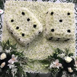 Large white floral funeral tribute with black dot accents and orchid sprays