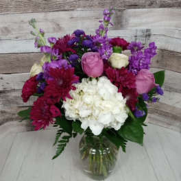Bouquet of pink, white, and purple flowers in a glass vase