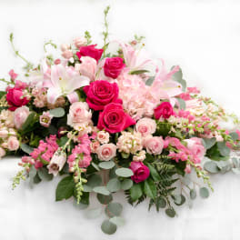Pink and white floral casket spray with roses and lilies