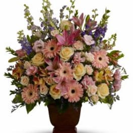 Large mixed bouquet in a brown urn vase with pink and cream flowers