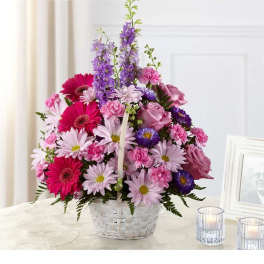 Pink and purple mixed flower arrangement in a white basket