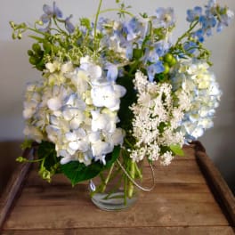 Blue and white hydrangea bouquet in a clear glass vase