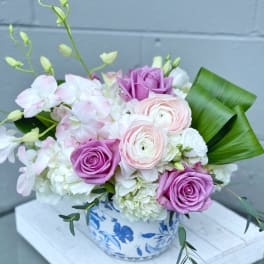 Pink and white flower arrangement in a blue-and-white ceramic vase