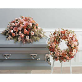 Peach and pink floral casket spray with a matching wreath on a stand