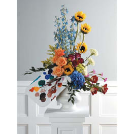 Colorful mixed bouquet in a white vase with a paint palette