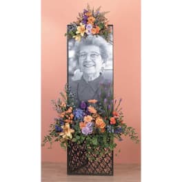 Standing sympathy floral tribute with a framed portrait and mixed flowers