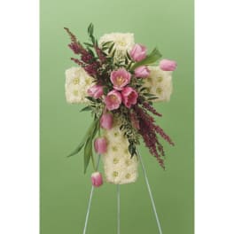 Floral cross made of white and pink flowers on a stand